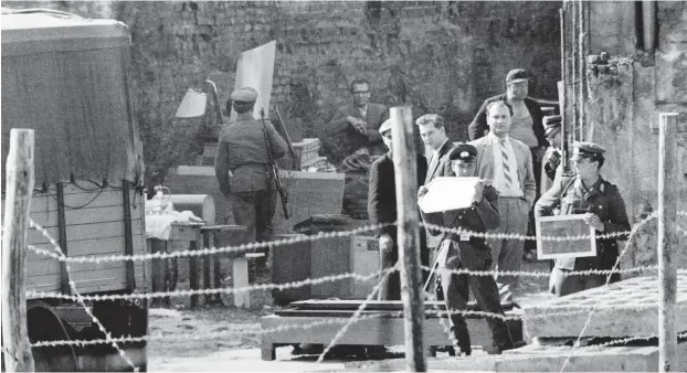  ?? Foto: akg/ Gert Schütz ?? Nach dem Mauerbau 1961: DDR-Grenzpoliz­ei »hilft« beim »Umzug«.