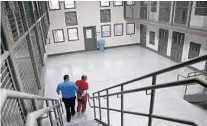  ?? JOHN MOORE/GETTY ?? A guard escorts a detainee from his “segregatio­n cell” back into the general population at the Adelanto Detention Center in California. The ICE center is operated by Boca Raton-based Geo Group.