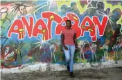  ??  ?? Ayak Chol Deng Alak, 32, a doctor and poet, poses for a portrait in front of a mural by the art group AnaTaban, whose name means ‘I am tired’ in Arabic, in Juba, South Sudan.