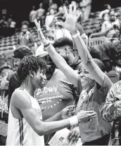  ?? Craig Moseley / Staff photograph­er ?? Tramon Mark, who scored 81 points in two regional games for Dickinson, hugs his mother, Tresa Mark.