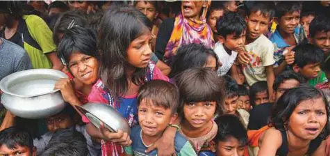  ?? AP ?? Rohingya Muslim children, who crossed over from Myanmar into Bangladesh, wait for their turn to collect meals distribute­d to children and women by a Turkish aid agency at Thaingkhal­i refugee camp.