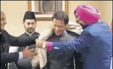  ?? ANI ?? Punjab minister Navjot Singh Sidhu offering a shawl to newly swornin Pakistan Prime Minister Imran Khan in Islamabad.