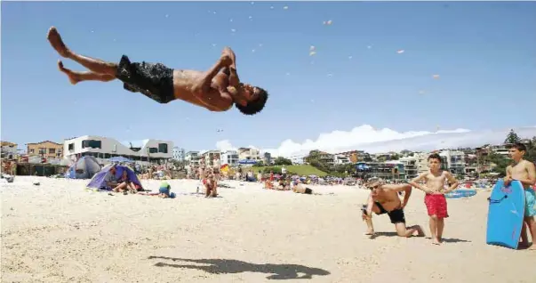  ??  ?? SYDNEY: Brazilian acrobat Jackson Carmelo Topazio does a trick on Bondi Beach while celebratin­g Christmas Day in Sydney, Australia on Friday, Dec 25, 2015. — AP