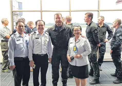  ?? PUBLIC RELATIONS TEAM FROM MAE FA LUANG AIRPORT ?? Australian anaestheti­st and underwater cave explorer Richard ‘Harry’ Harris poses for a photo with Thai officials who saw off his team of divers at Mae Fa Luang airport in Chiang Rai yesterday.
