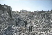  ?? SERGEY PONOMAREV/THE NEW YORK TIMES ?? People search through the rubble of an apartment building Sunday in Iskenderun, Turkey, after it collapsed during last week’s earthquake. The quake’s death toll rose over 33,000.