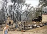  ?? ?? The Associated Press
A resident passes a lodge that burned during the McKinney Fire, Tuesday, in Klamath National Forest, Northern Calif.