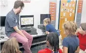  ?? SUE OGROCKI/ ASSOCIATED PRESS ?? New Hope Case Manager David Howell, left, Junior Bowersock, right, and other students in the New Hope after-school program at Mark Twain Elementary School in Tulsa, watch a video on overcoming obstacles. Case managers are leaving the profession at an alarming rate, but the Legislatur­e can help.