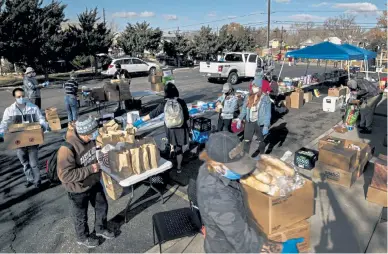  ?? Woody, Special to The Denver Post William ?? Grand Junction Mutual Aid volunteers unload boxes of donated food to be distribute­d at a pop-up food bank in the parking lot of the Unitarian Universali­st Congregati­on of the Grand Valley in Grand Junction on Nov. 24.