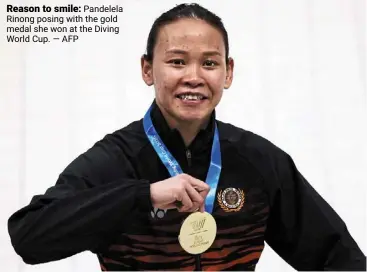  ?? — aFP ?? Reason to smile: Pandelela rinong posing with the gold medal she won at the diving World Cup.