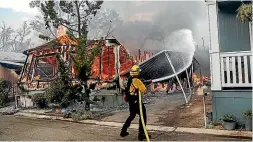  ?? AP ?? Firefighte­rs battle flames at the Alpine Oaks Estates mobile home park during a wildfire on Saturday in Alpine, California.