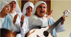  ??  ?? Nun Maria Valentina de los Angeles (right) plays the guitar and sings at a convent.