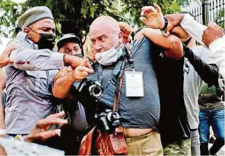  ?? AFP ?? En medio de las manifestac­iones, un fotógrafo español fue arrestado por la Policía cubana.