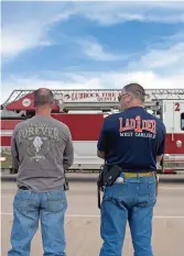  ?? ?? Los socorrista­s del condado de Lubbock hacen una pausa cuando pasa la procesión del jefe de bomberos Zeb Smith