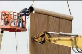  ?? GREGORY BULL — THE ASSOCIATED PRESS ?? Crews work on a border wall prototype near the border with Tijuana, Mexico, Thursday in San Diego. Companies are nearing an Oct. 26 deadline to finish building eight prototypes of President Donald Trump’s proposed border wall with Mexico.