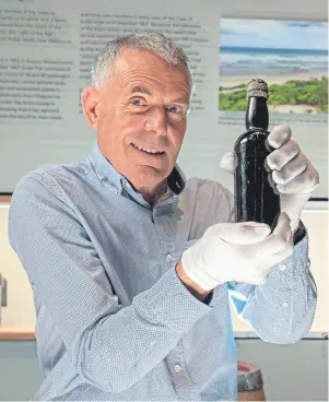  ??  ?? CHEERS: Diver Jim Anderson with the 150-year-old bottle of Tennent’s stout