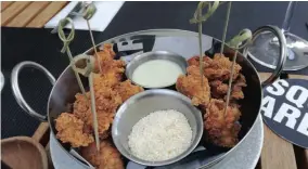  ??  ?? ADDICTIVE: Popcorn chicken (buttermilk-fried chicken nuggets, blue cheese cream and popcorn powder).