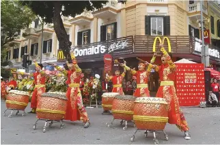  ??  ?? PERFORMERS BEAT drums during the opening ceremony of the first McDonald’s fastfood chain restaurant in the capital Hanoi on Dec. 2. Global burger behemoth McDonald’s opened its first branch in the historic heart of communist Hanoi. The restaurant is...