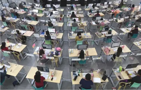  ?? — AFP file photo ?? Registered teachers wearing face masks and shields against Covid-19, conduct tele-conferenci­ng with struggling students helping them in their school lessons through online distant learning at a local government-sanctioned online tutorial class in Taguig City, south of Manila on March 3 this year.