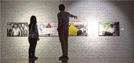  ?? PIC BY ASYRAF HAMZAH ?? Visitors viewing some of the photos that are on display at the Tribute to Life exhibition at Galeri Prima in Kuala Lumpur recently.