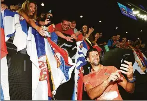  ?? Graham Denholm / Getty Images ?? Novak Djokovic poses for a selfie with fans after the Arena Showdown charity match against Nick Kyrgios ahead of the Australian Open at Melbourne Park on Friday in Melbourne.