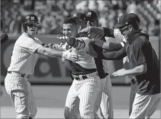  ?? SETH WENIG/AP PHOTO ?? Gleyber Torres of the New York Yankees, second from left, celebrates his walk-off RBI single with teammates after Wednesday’s game against the Toronto Blue Jays at Yankee Stadium in New York.