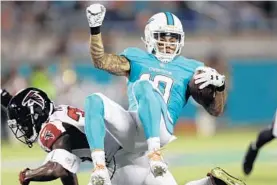  ?? WILLIE J. ALLEN JR./AP ?? Miami wide receiver Kenny Stills, top in Thursday’s game, got hurt on a 1-on-1 drill Monday during the Dolphins practice. It was his first time being injured during practice.