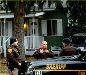  ?? AP FILE PHOTO ?? Three Oakland County Sheriff's deputies survey the grounds outside of the Crumbley residence while seeking James and Jennifer Crumbley, parents of Oxford High School shooter Ethan Crumbley, Dec. 3, in Oxford, Mich.