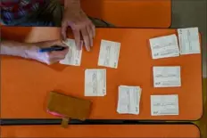  ?? Paul Ratje/The New York Times ?? A volunteer prepares COVID-19 vaccinatio­n cards in Albuquerqu­e, N.M. The card never quite fit in your wallet, so it’s no surprise you may have misplaced it by now.