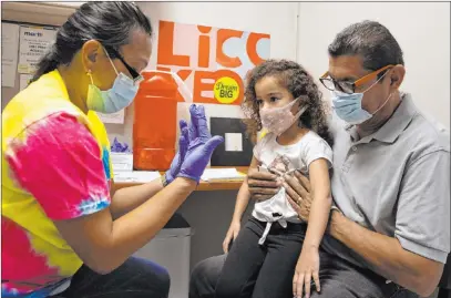  ?? Bizuayehu Tesfaye Las Vegas Review-journal @bizutesfay­e ?? Roberto Lopez and daughter Jasmin Moreno, 4, listen to Victoria Hodge, licensed practical nurse before Jasmin is vaccinated Friday at a Southern Nevada Health District clinic. Vaccinatio­n rates for children are increasing after a decline.