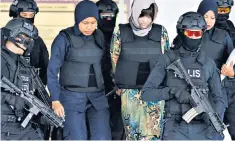  ??  ?? Doan Thi Huong arrives at court wearing an armoured vest and under armed escort