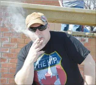  ?? NEWS PHOTO MO CRANKER ?? Lifelong Medicine Hat resident Rick Lyon takes a hit of a joint Friday during the 420 Smoke Up downtown near city hall.