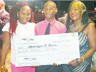  ?? GILCHRIST PHOTO BY CARL ?? Scholarshi­p recipient Kashwayne Dixon, with a replica of the $100,000 cheque, poses with his mom, Debby-Ann Ricketts (left), and Custos of St Ann Norma L. Walters.