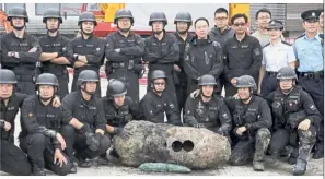  ?? — AP ?? Mission accomplish­ed: The bomb squad posing with the deactivate­d bomb.