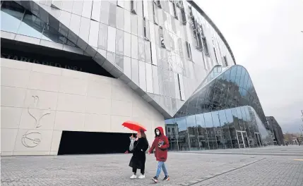  ?? AFP ?? Women wearing face masks walk outside the Tottenham Hotspur Stadium in London.