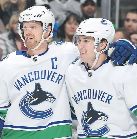  ?? AARON POOLE/NHLI VIA GETTY IMAGES/FILES ?? Derrick Pouliot gets a hug from Canucks captain Henrik Sedin during a game against the Kings last month. Pouliot’s passing has brought quicker zone exits for the team.