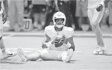  ?? JOHN MCCALL/SUN SENTINEL ?? Dolphins quarterbac­k Tua Tagovailoa sits up after being sacked by the Bills defense during the first quarter Sunday.