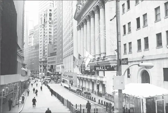  ??  ?? People walk by the New York Stock Exchange at the end of the trading day in New York City. US stocks managed gains for a second straight week, as investors clung to a blind faith that politician­s will
resolve the looming fiscal cliff crunch. (AFP)