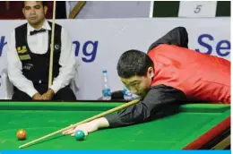  ?? — AFP ?? BANGALORE: This file photo taken on November 29, 2014 shows China’s Yan Bingtao playing a shot against Pakistan cueist Mohammad Sajjad during the men’s finals of the IBSF World Snooker Championsh­ip in Bangalore, India.