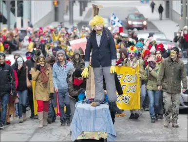  ?? JOHN KENNEY  THE GAZETTE ?? A protest against pending tuition hikes by the Quebec government, billed as La Grande Mascarade, makes its way along St. Alexandre St. Thursday, replete with masked students and a hanging effigy.