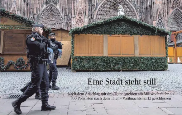  ?? FOTO: DPA ?? Polizisten gehen nach dem tödlichen Anschlag über den geschlosse­nen Weihnachts­markt vor dem Straßburge­r Münster.
