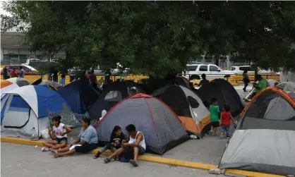  ??  ?? Migrants, many of whom were sent back to Mexico under Migrant Protection Protocols, at a makeshift encampment in Matamoros, Mexico, on 24 August. Photograph: Loren Elliott/Reuters
