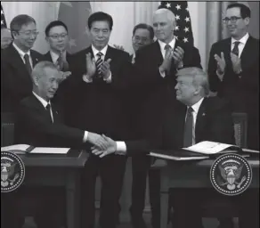  ?? ASSOCIATED PRESS ?? President Donald Trump shakes hands with Chinese Vice Premier Liu He, after signing a trade agreement Wednesday in the East Room of the White House in Washington.