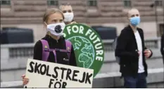 ?? FREDRIK SANDBERG / TT VIA AP ?? Swedish climate activist Greta Thunberg holds a poster reading “School strike for Climate” as she protests in front of the Swedish Parliament Riksdagen, in Stockholm, Friday .
