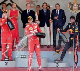  ?? — AP ?? Ferrari’s Sebastian Vettel (centre) celebrates on the podium along with second placed Kimi Raikkonen and Red Bull’s Daniel Ricciardo at the Monaco street circuit.