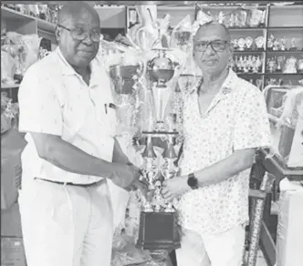  ?? ?? Trophy Stall proprietor, Ramesh Sunich (right), hands over the Legends Over50 winning trophy to the GSCL president Ian John.