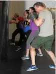  ?? MICHILEA PATTERSON — DIGITAL FIRST MEDIA ?? Scott Loughin does boxing combinatio­ns using a bag alongside women during a class at Ignite Fitness Studio in West Vincent.