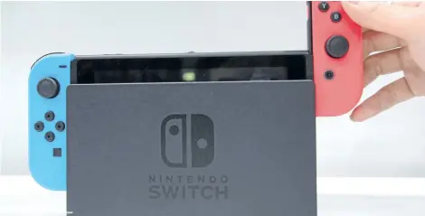  ?? KOJI SASAHARA/THE ASSOCIATED PRESS ?? A model puts the controller on to the Nintendo Switch during a presentati­on event of the new Nintendo Switch in Tokyo, Friday, Jan. 13, 2017. Nintendo’s resurgence to the front of the pack in the video game industry surprised even some within the company itself.