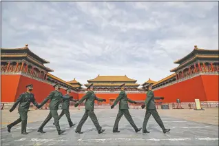  ?? (File Photo/AP/Andy Wong) ?? Soldiers wearing protective face masks march on March 12, 2020, past the closed entrance gates to the Forbidden City, usually crowded with tourists before the coronaviru­s outbreak in Beijing.