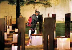  ?? [PHOTO BY SARAH PHIPPS, THE OKLAHOMAN] ?? Krista Doll takes a moment at her mother’s chair, Jamie Genzer, before running in the half marathon on Sunday. Doll carried 22 pounds in her backpack to remember the 22 years she has been without her mother.