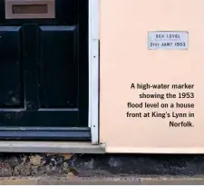  ??  ?? A high-water marker showing the 1953 flood level on a house front at King’s Lynn in Norfolk.